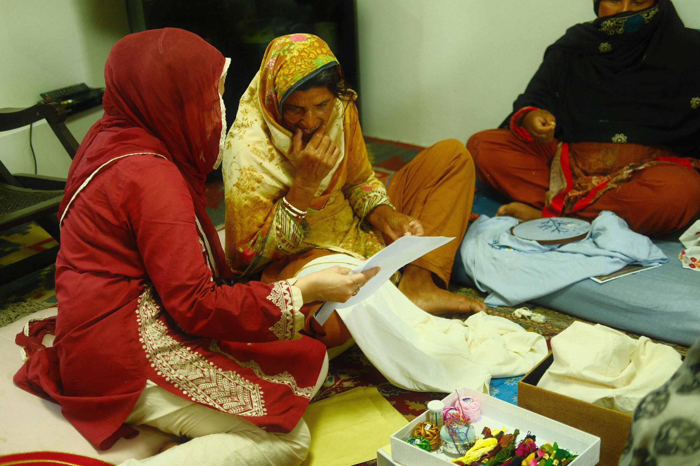Artisan reviewing an embroidery pattern before stitching