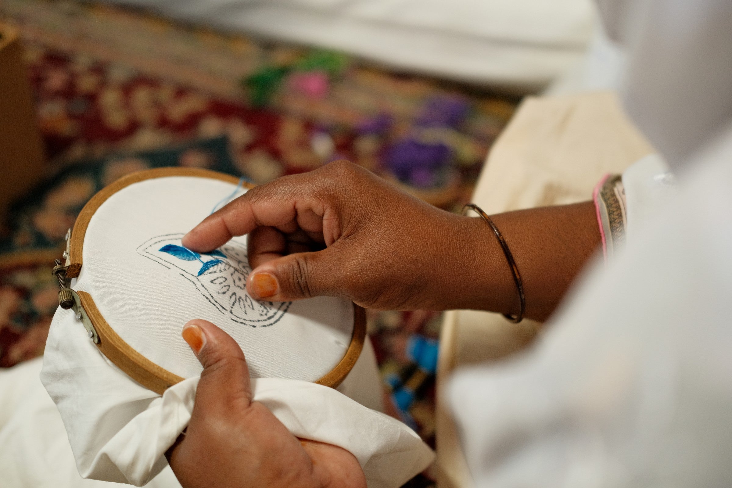 Artisan hand-sketching an embroidery motif